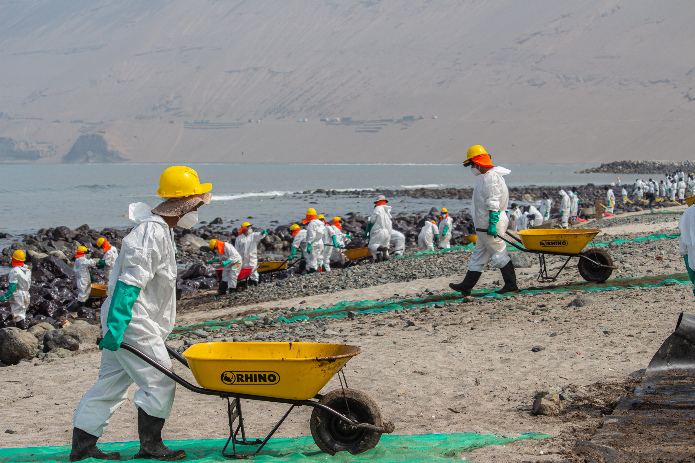 People cleaning up oil spill in Peru